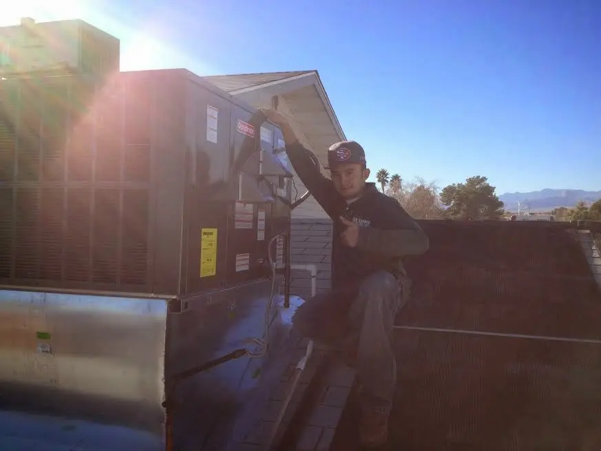 HVAC technician performing Air Duct Cleaning on a rooftop unit in Valley Stream